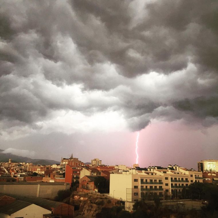 Un rayo cae sobre la ciudad bajo un cielo de tormenta